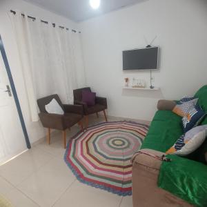 una sala de estar con un sofá y una silla en Lar, doce mar., en Paraty