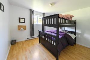 a bedroom with a bunk bed with purple sheets at La Maison Big Bill in Murdochville +31 photos