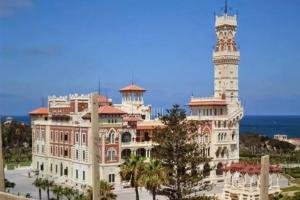 ein großes Gebäude mit einem Uhrturm darüber in der Unterkunft SUN SEA HOLIDAy 13 ALMOAYYED STREET in Alexandria