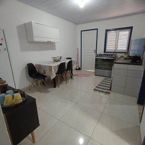 Una cocina y un comedor con mesa y sillas. en Lar, doce mar., en Paraty 1 foto más