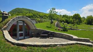 a circular building with a table and chairs in a yard at Adventure Camping Kosovo in Prizren