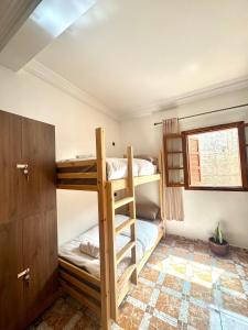 a room with two bunk beds and a window at SurfsHub Hostel Tghazout Bay Tamraght in Tamraght Ouzdar +32 photos