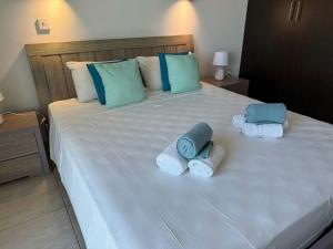 a large bed with towels and pillows on it at Too Coool 1 Bedroom Apartment Coralli Resort in Protaras