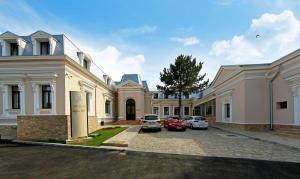 a large mansion with cars parked in the driveway at Hotel Saint Germain in Brăila