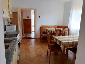 a kitchen and dining room with tables and chairs at Casă de oaspeți ORSO in Sovata