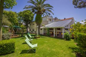 einen Hof mit zwei Stühlen und einem Haus in der Unterkunft hosteria Dalmacia in Pinamar