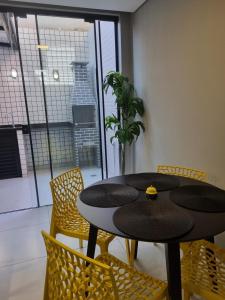 a table and chairs in a room with a window at A 700m da Praia e do Shopping, Liberdade, Churrasq, Garagem e Estaciona Livre in Balneário Camboriú