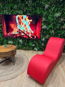a red chair in a living room with a fireplace at F & C Love Spa, Sauna and Tantra in Chartrettes