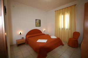 a bedroom with a red bed and a chair at Residence Club Barbara in Ostuni