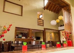 a restaurant with leather chairs and a bar with red boxes at Hotel Poincenot in El Chalten