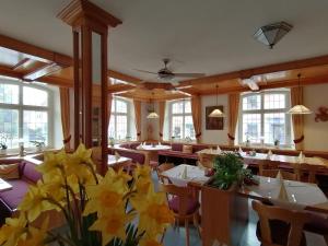 a restaurant with tables and yellow flowers in the middle at Hotel & Restaurant Zum Schwanen in Neuried