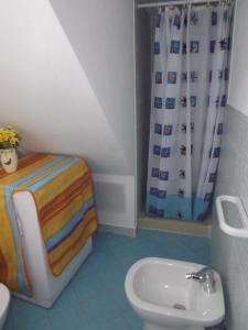 a bathroom with a toilet and a shower curtain at Relax a Calasapone in SantʼAntìoco