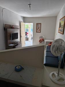 - un salon avec un canapé bleu et un ventilateur dans l'établissement Casa em Tamandaré a 1km de Carneiros no Condomínio Cote d' Azur, à Tamandaré