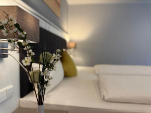 un vaso con fiori su un tavolo in una stanza di Mirage City Hotel Stuttgart Zentrum a Stoccarda