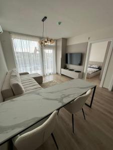 a living room with a dining table and a couch at Apartamentai INFINITUM SEA in Palanga