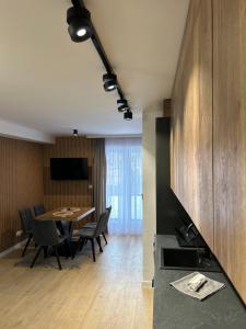 科尔别卢夫Leśne Wzgórze Apartamenty的配有桌椅的厨房和餐厅