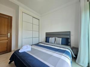a bedroom with a large bed with blue sheets at Cabo Alegre in Martil +30 photos