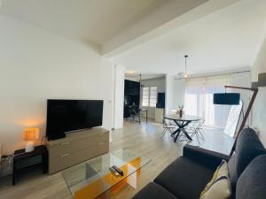 un soggiorno con un divano, una TV e un tavolo di Appartement T3 - 1er étage a Banyuls-sur-Mer