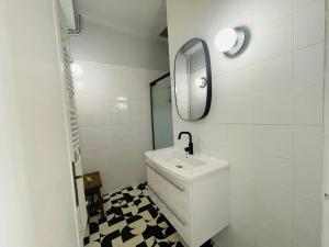 un bagno bianco con lavandino e specchio di Appartement T3 - 1er étage a Banyuls-sur-Mer
