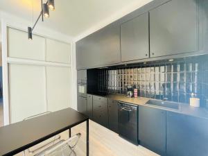 una cucina con armadi blu e piano di lavoro nero di Appartement T3 - 1er étage a Banyuls-sur-Mer