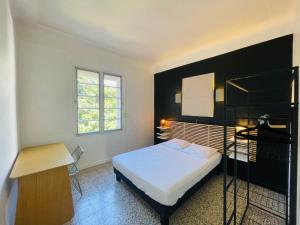 una camera da letto con un letto, una scrivania e una finestra di Appartement T3 - 1er étage a Banyuls-sur-Mer