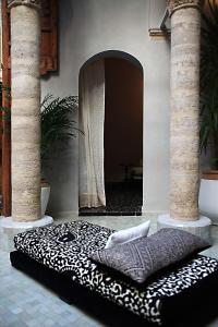 ein schwarzes und weißes Bett in einem Zimmer mit zwei Säulen in der Unterkunft L'Alcazar in Rabat