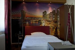 a bedroom with a wall mural of a bridge at Hotel Erbprinzenhof in Karlsruhe +9 photos