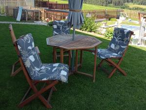 two chairs and a wooden table with an umbrella at Wohlfühlwohnung in Rappottenstein +7 photos
