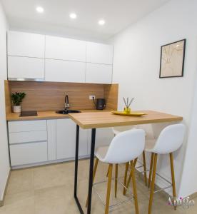 a kitchen with a wooden table and white chairs at Stari View-Free Parking in Mostar