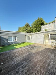 una casa con una terrazza in legno nel cortile sul retro di Ferienwohnung Hügelstraße a Wuppertal
