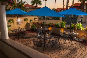een groep tafels en stoelen met blauwe parasols bij Inn on Charlotte Boutique Hotel in St. Augustine