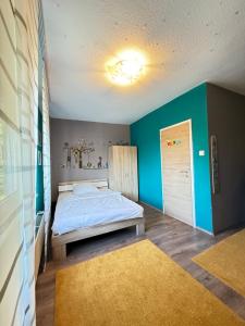 una camera da letto con un letto e una parete blu di Ferienwohnung Hügelstraße a Wuppertal