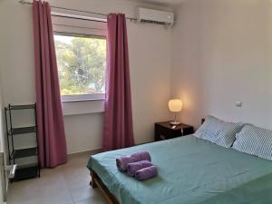 a bedroom with a bed with a purple pillow on it at Jimmy's Romantic Getaway in Egina