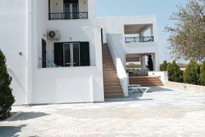 a white house with stairs and a stair case at Jimmy's Romantic Getaway in Egina