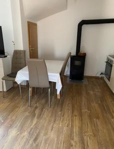 Habitación con mesa, 2 sillas y TV. en Adria, en Brodarica