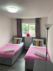 a room with two beds and a window at 2 bed house sleeps 4-5 in Liverpool