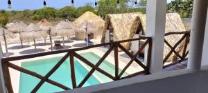 a view of a resort with a pool and straw umbrellas at Maha Yaxja in Mahahual