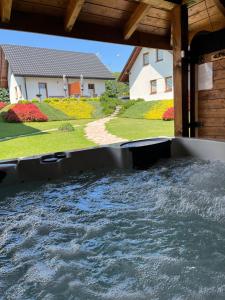 a pool of water in a backyard with a house at Apartamenty Jaworzynka in Jaworzynka
