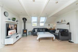 a living room with couches and a table and a fireplace at 272-Ringkobing-Vestklitvej-22 in Klegod
