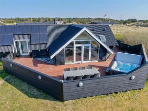 a large deck with a swimming pool and a house at 272-Ringkobing-Vestklitvej-22 in Klegod