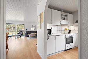 Una cocina con electrodomésticos blancos y una sala de estar. en 127-Ringkobing-Birkealle-1, en Nørby 22 fotos más