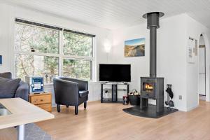 Una sala de estar con chimenea y un sofá. en 127-Ringkobing-Birkealle-1, en Nørby