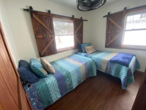 a bedroom with two beds and two windows at The Farmhouse ranch in Stockton