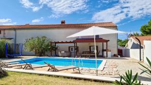 une villa avec une piscine et un parasol dans l'établissement Villa John, à Pula