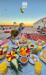 マラケシュにあるRiad Sun Medina Terraceのビーチに食べ物と飲み物が置かれたテーブル
