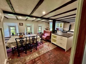 a kitchen and dining room with a table and chairs at Powis House East Cottage in Stirling