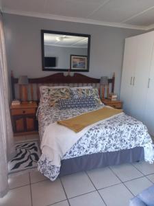 a bedroom with a bed with a mirror on the wall at 7 Diaz Street Da Nova in Mossel Bay