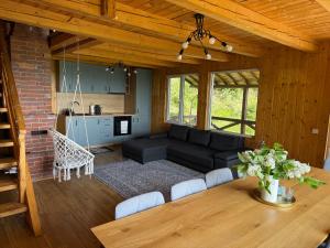 a living room with a black couch and a table at Panoramic House in Mărişel