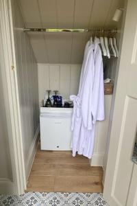 - une cuisine avec des serviettes blanches accrochées au mur dans l'établissement Stamping Cottage near Isles of Scilly Park and Ride, à Penzance