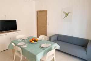 a living room with a table and a blue couch at Appartamento Il Colibrì in Pignataro Maggiore